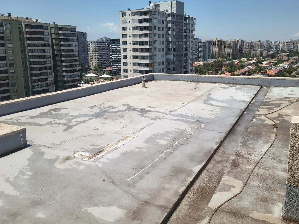 Azotea de un edificio limpia, con el pretil y los desagües a la vista, antes de impermeabilizar