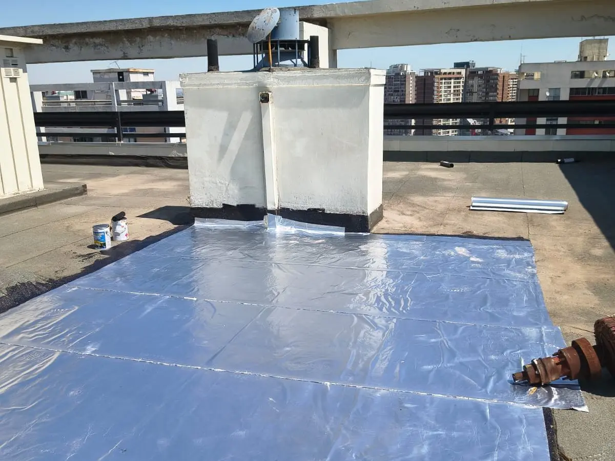 Membrana asfáltica instalada junto a la base de una sala de equipos en la azotea de un edificio